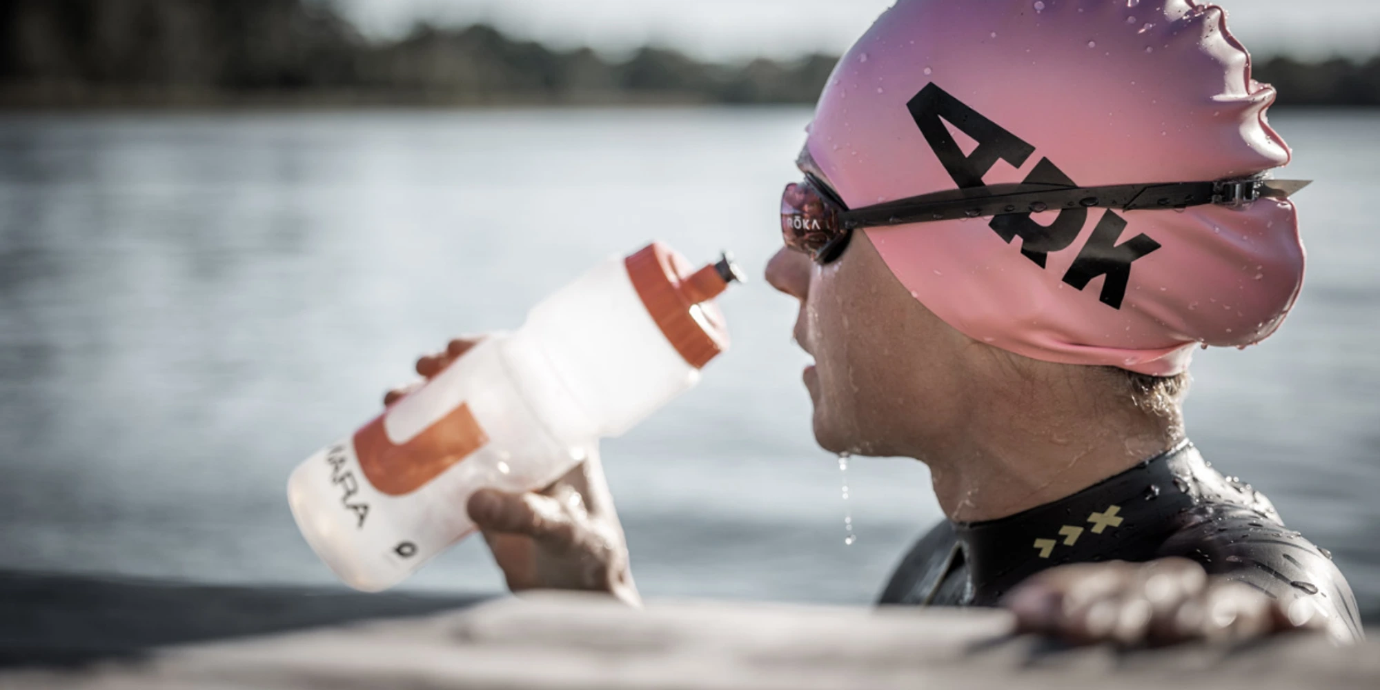 Swimmer holding onto something while drinking from a bottle