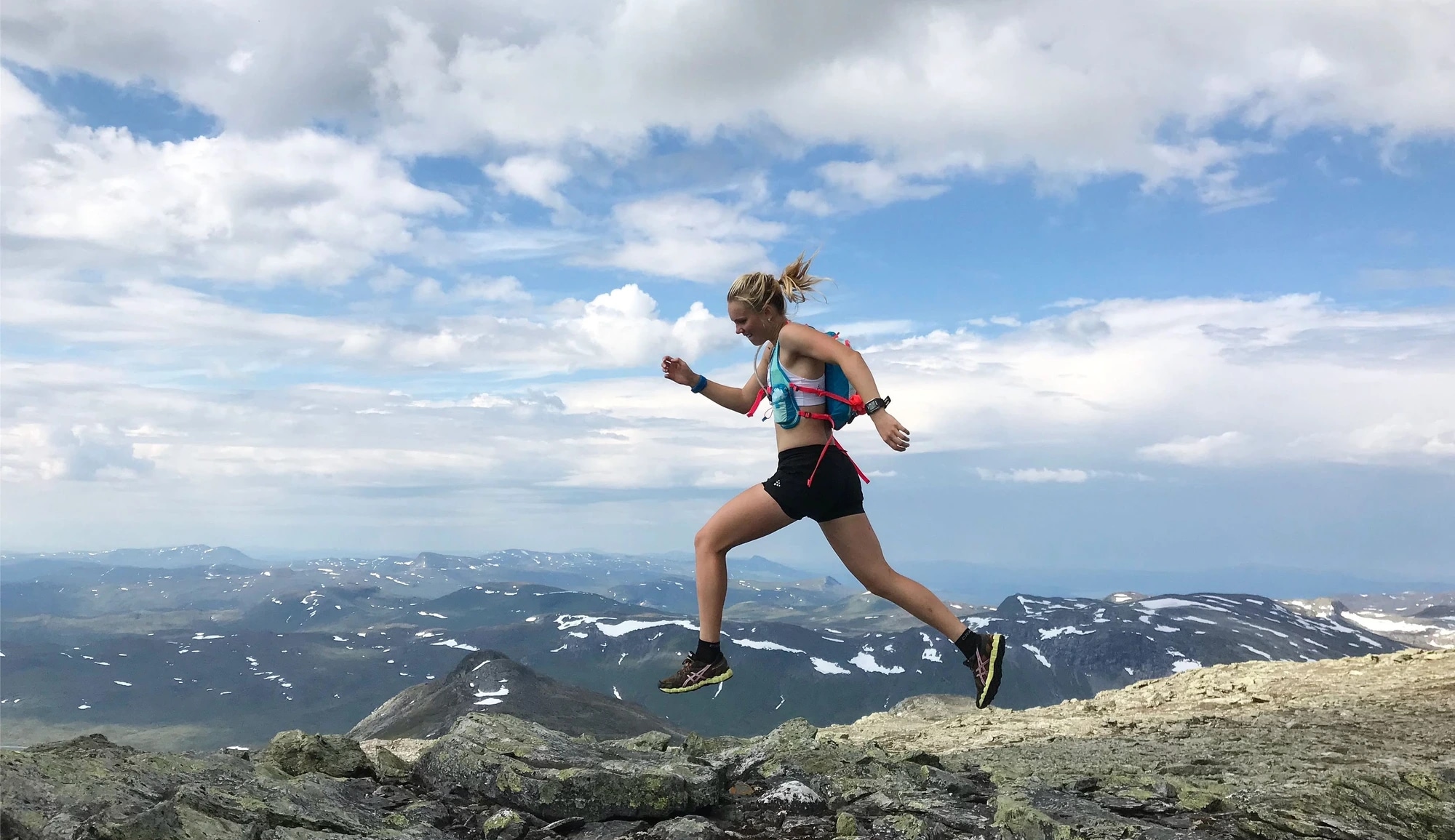 Kvinna springer bland bergen